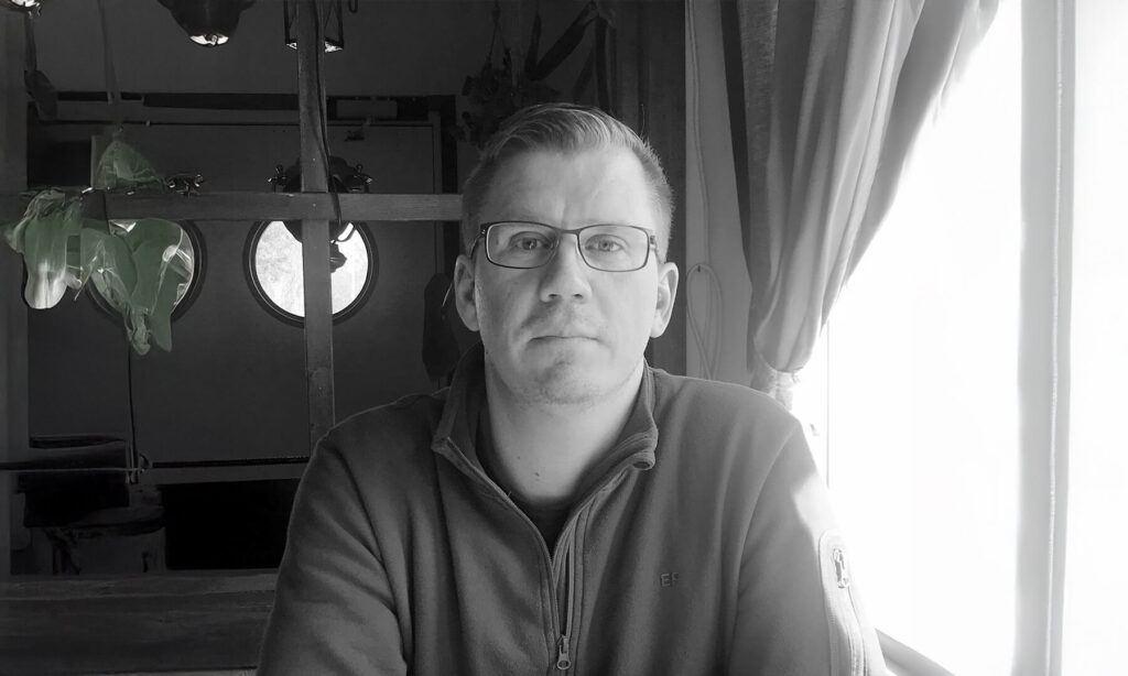 Man med glasögon, gråvit bakgrund. Studerande